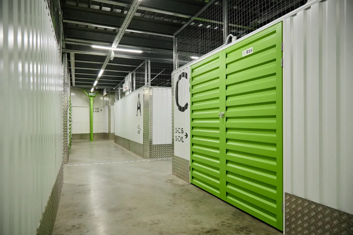 Pasillo de instalaciones de un centro de trasteros con módulos cerrados y puertas metálicas