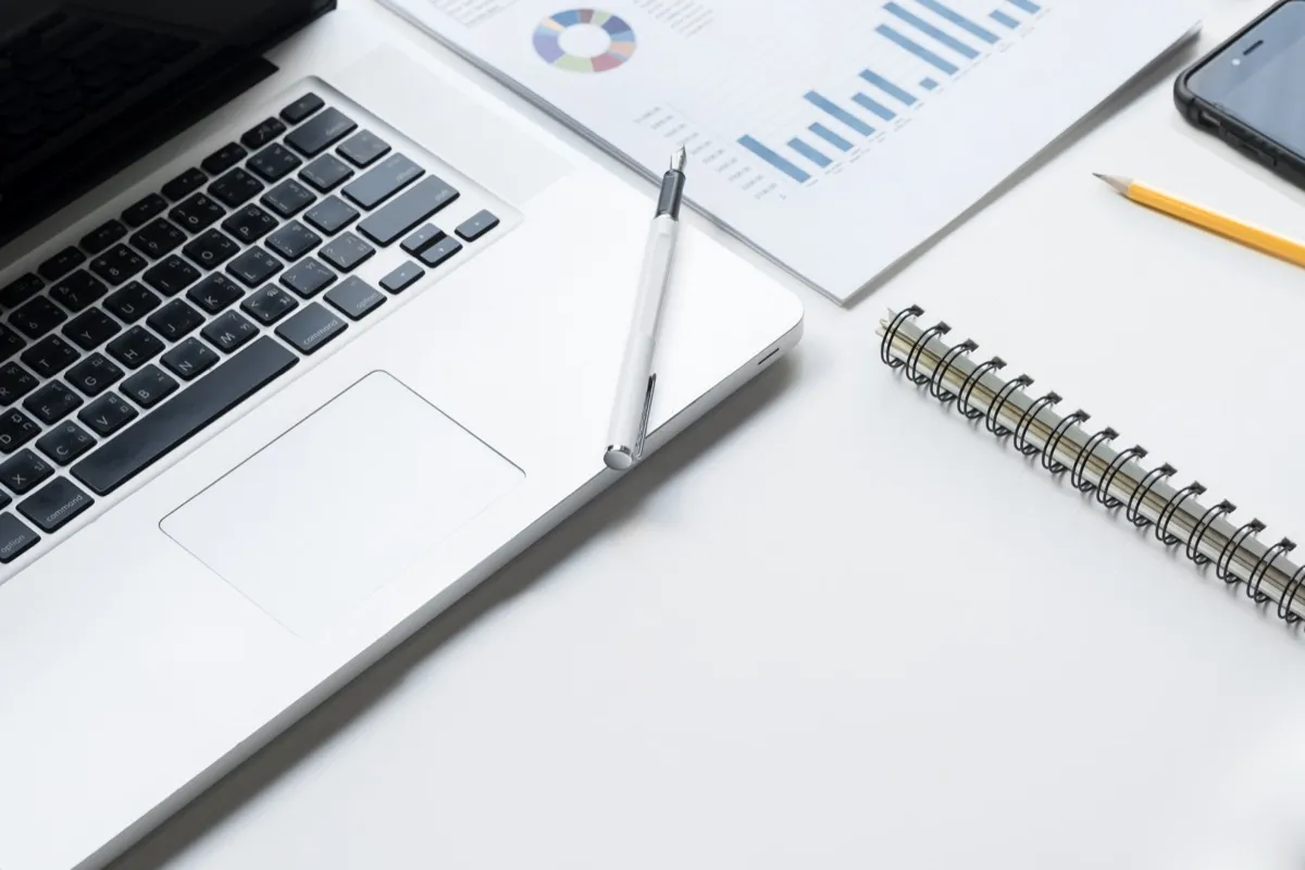 Puesto de trabajo con ordenador portátil, tablet y gráficos comparativos para digitalizar la gestión