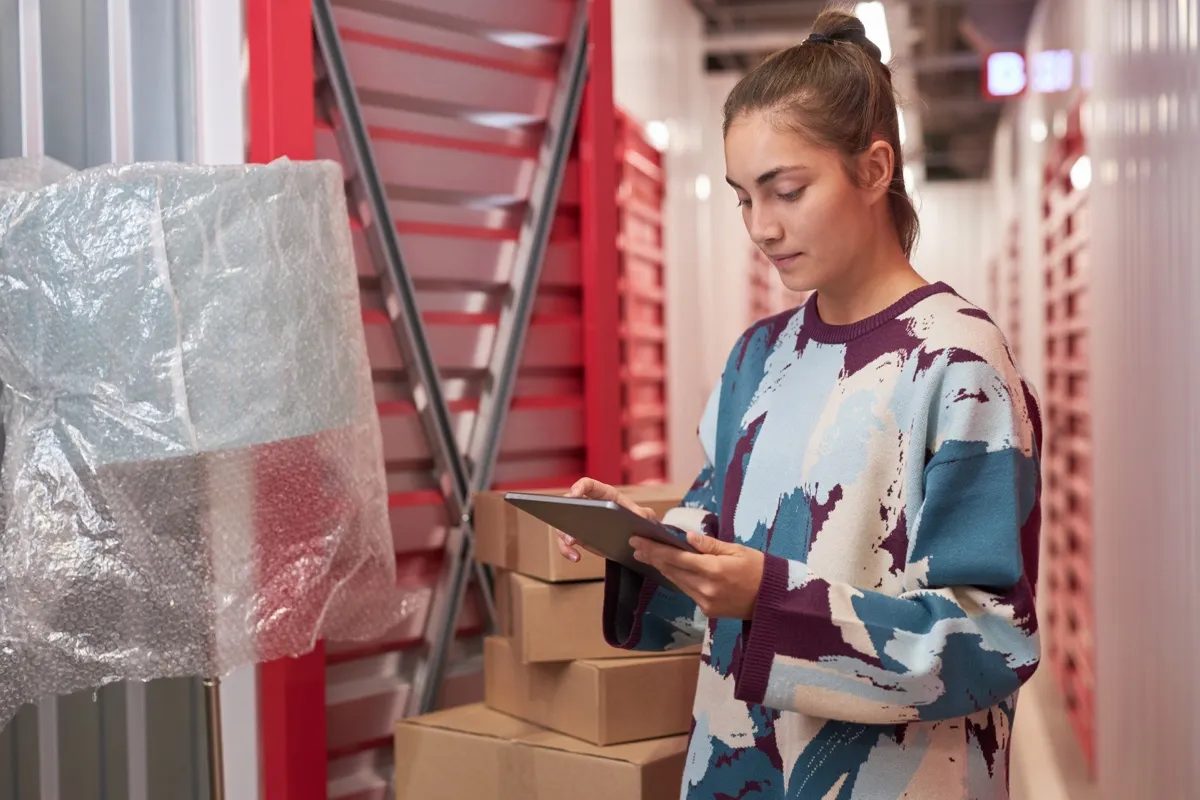 Operadora revisando la lista de unidades en una tablet en las instalaciones de un centro de trasteros