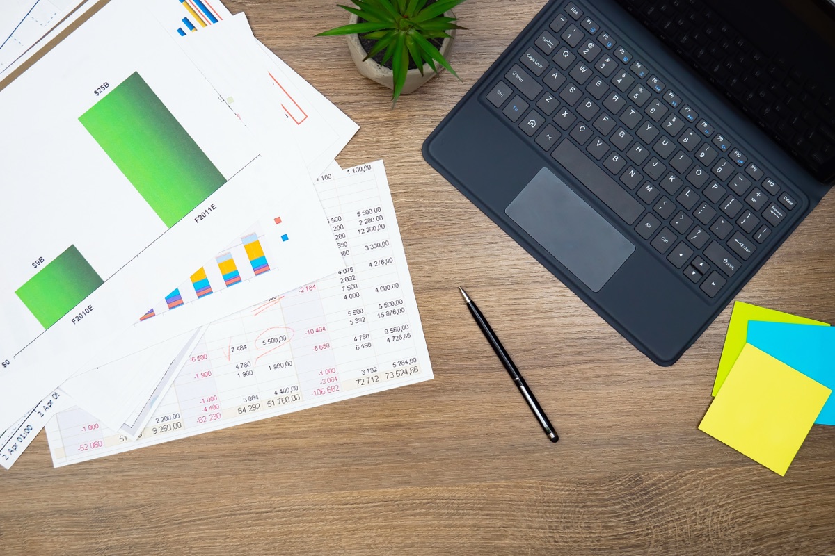Mesa de trabajo con análisis de métricas, gráficos de rentabilidad y calculadora de negocio