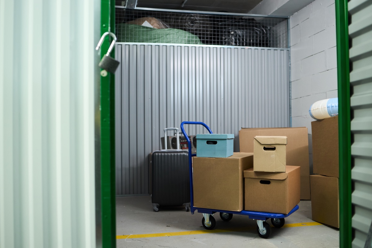 Interior de un módulo de trastero con carro de transporte y cajas apiladas